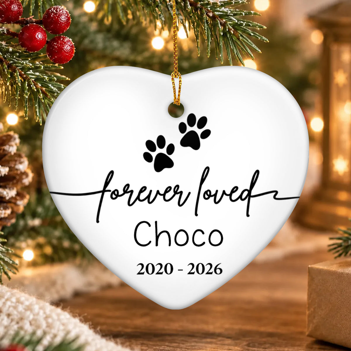 Forever Loved Personalized Ceramic Ornament heart with paw prints and Choco, hanging by pine branch and lights