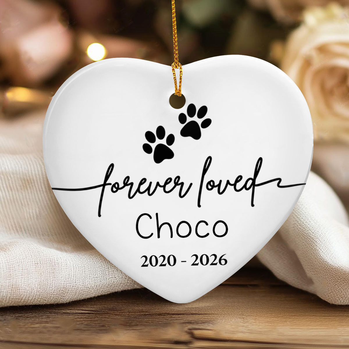 Forever Loved Personalized Ceramic Ornament with Choco 2020 - 2026 resting on cream cloth near a rose